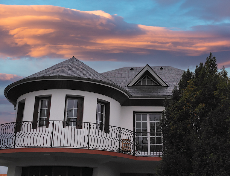 couverture toiture en ardoise sur tourelle et toiture en ardoise sur maison de caractère au coucher de soleil