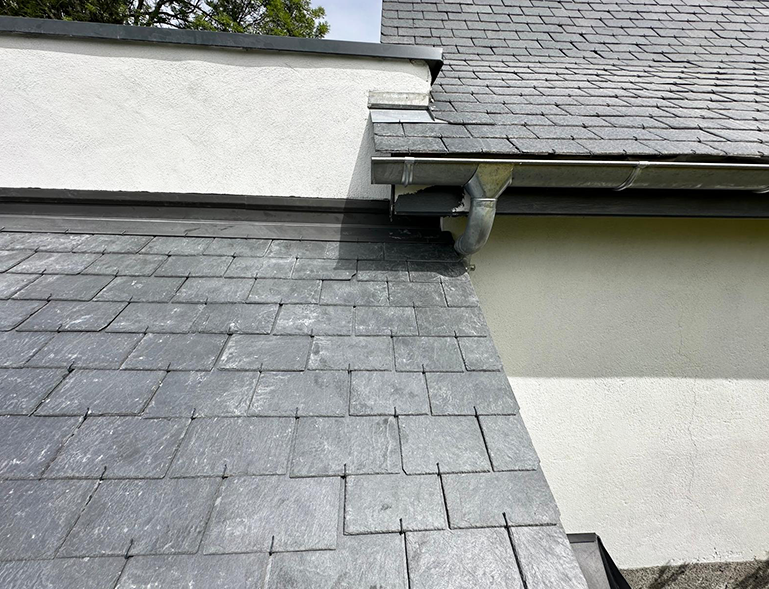 détail pose d'ardoises en couverture toiture avec gouttière zinc et raccord en rive de mur