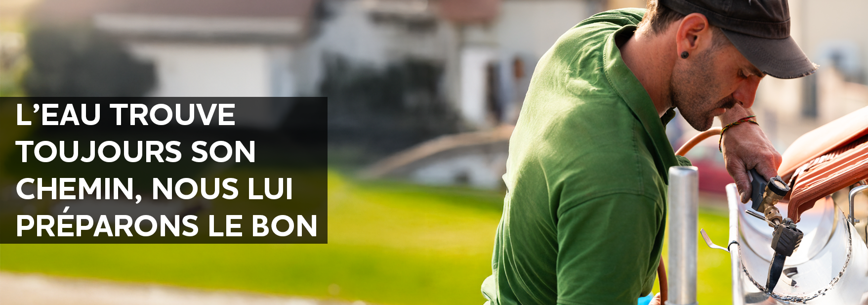 zingueur Troyano Charpente soudant une gouttière zinc sur toiture en tuile rouge