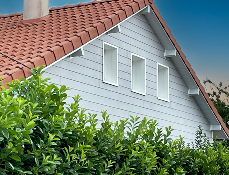 bardage bois gris posé sur façade de maison avec toiture tuiles rouges