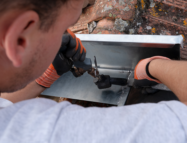 couvreur réalisant un raccord zinc sur une toiture