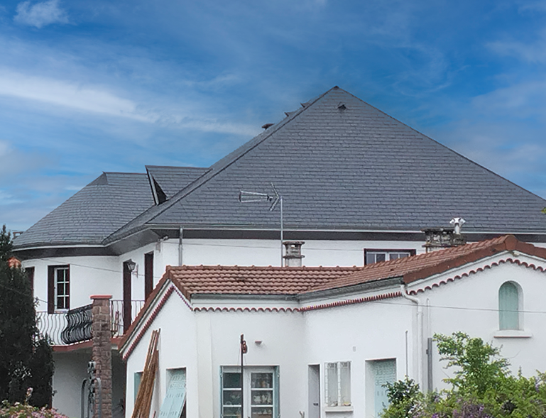 rénovation couverture toiture en ardoise sur grande maison bourgeoise avec toiture tuile rouge en contrebas